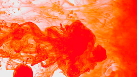 Orange-Paint-Or-Dye-Dropped-Into-Water-Against-White-Background-To-Create-Swirling-Colourful-Smoke-Background-1